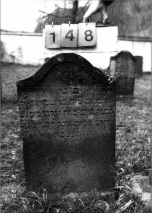 Grabstein 148 (Index: 99798423) Material: Sandstein Zustand: gut Maße HxBxT: 80x48x8 cm Beschreibung: Stele mit Sattelbogenabschluß Symbolik: Blüte: Grabstein 148
