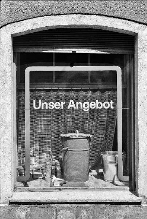 Schaufenster mit Mülltonnen und Aufschrift "Unser Angebot"