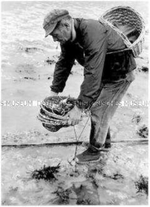 Älterer, rauchender Mann beim Fischen (Altersgruppe 14-17)