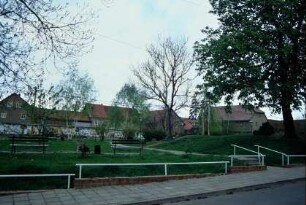 Dorfplatz mit gepflegten Grünanlagen und Bäumen