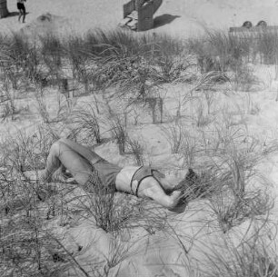 Elisabeth Gremmler liegt auf einer Düne umgeben von Strandhafer