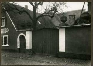Haus Nr. 23. Tor, oben offen. Sandsteinvasen aus dem Dürkheimer Schloß