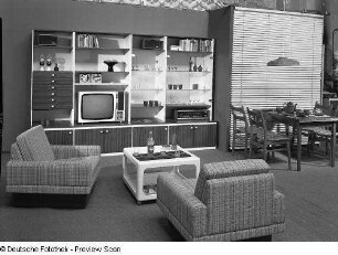 Anbauwand "Poel" : Wohnzimmermöbel. Anbauwand (1974; Möbelkombinat Nord (MKN)). Ansicht mit Sesseln, Couchtisch und Eßplatz
