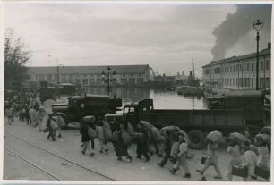 Matrosen mit Gepäck am Hafen