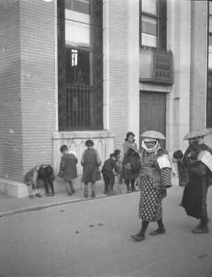 Straßenbild in Fushiki : Ansicht mit zwei Frauen und einer Grupe von Kindern. Blick gegen ein modernes Gebäude im westlichen Stil