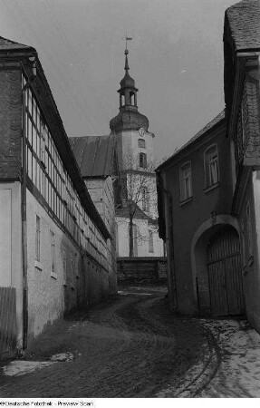 Kirche und Wohnhäuser an einer Dorfstraße