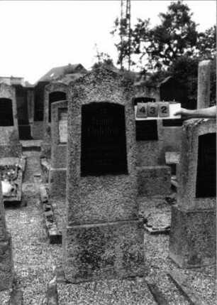 Grabstein 432 (Index: 99797497) Material: Granit, schwarze Glasplatte Zustand: leicht verwittert Maße HxBxT: 165x50x20 cm Beschreibung: Stele, giebelartiger Abschluß, Sockel: Grabstein 432