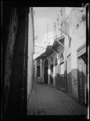 Tunis (Tunesien): Enge Gasse mit der Kuppel einer Moschee im Hintergrund