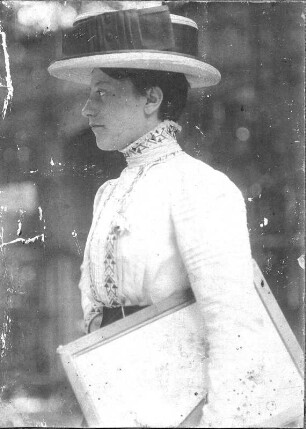 Porträt einer jungen Frau mit Hut und Mappe