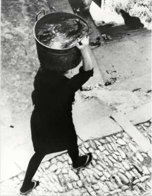Frau beim Wasserholen