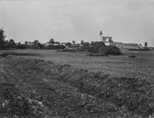 Dorf : Blick über ein Feld auf ein Dorf