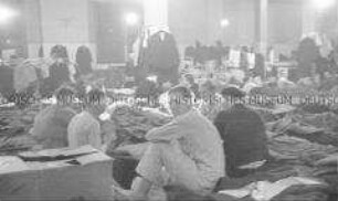 Selbstversenkung des Hochseepassagierdampfers "Columbus" am 19. Dezember 1939, Besatzungsangehörige im Internierungslager auf Ellis Island, auf einfachen Feldbetten sitzend