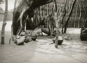 Adumre bei Garua, Nord-Kamerun. Weber bei der Arbeit am Schaftwebstuhl hinter dem Schutz von Flechtmatten