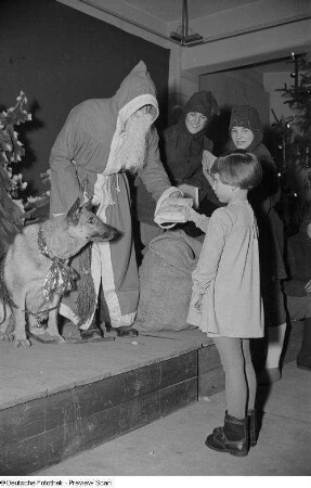 Weihnachtsmann, einem Mädchen ein Geschenk überreichend