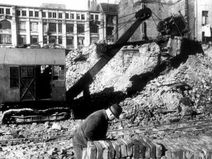 Hamburg-Altona. Mit einem Bagger werden Trümmerberge beseitigt. Ein Arbeiter stapelt wiederverwendbare, geputzte Ziegelsteine. Trümmerfrauen und -männer waren die Helden der ersten Stunde
