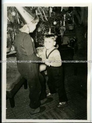 Kinder bei einer Silvesterfeier? neben einem Weihnachtsbaum
