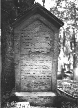 Grabstein 962 (Index: 99899493) Material: Sandstein Zustand: fast völlig verwittert Maße HxBxT: 150x74x25 cm Beschreibung: aufgesockelte Stele mit auskragendem Dreiecksabschluss: Grabstein 962
