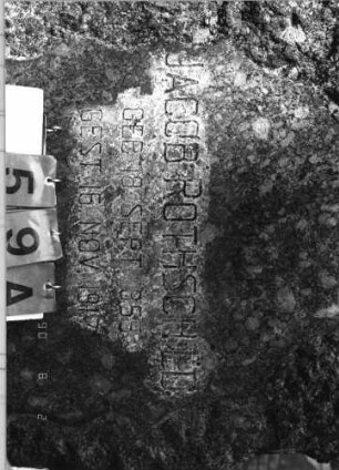 Grabstein 59 (Index: 99793115) Material: Granit (?) Zustand: gut Maße HxBxT: 194x80x34 cm Beschreibung: Naturstele, grob behauen, Schriftfeld geglättet, Grabeinfassung: Grabstein 59A