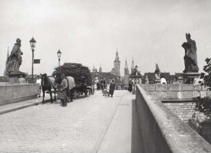 Würzburg. Alte Mainbrücke (1473-1488). Straßenbrücke. Blick nach Osten zur Altstadt. Im Vordergrund zweigesänniges Fuhrwerk mit Dühnnholzladung und nebenhergehendem Kutscher