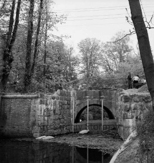 Brücke des Mühlenredder über dem Abfluss des Schlossgrabens: Renovierung: Seitenansicht von Süden: oben Arbeiter beim Aufbringen eines Schwarzteerbelags