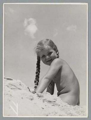 Nacktes Mädchen sitzt am Strand