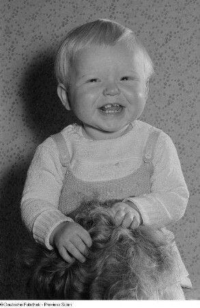 Portrait eines Kleinkindes auf den Schultern einer erwachsenen Person