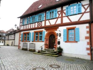 Stadtbild-Altes Schulhaus über Traufseite mit Fachwerk-Obergeschoß auf steinernem Stock sowie Renaissance-Portal