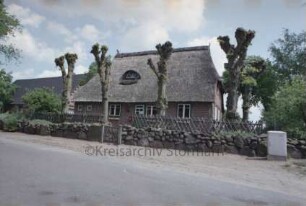 Poststraße 14: Fachwerkhaus mit Reetdach: traufständige Straßenfront mit Eingangstür und Dachgaube: rechts Wohntrakt, links ehemaliger Wirtschaftstrakt