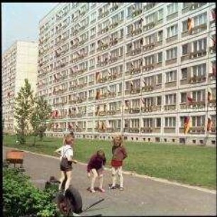 Kinder vor Plattenbau in der Lichtenberger Straße an einem Feiertag (1. Mai)