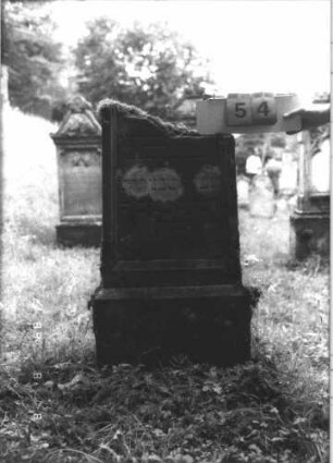 Grabstein 54 (Index: 99799410) Material: Sandstein Zustand: verwittert, oberer Teil abgebrochen Maße HxBxT: 107x54x16 cm Beschreibung: Stele, Oberteil abgebrochen, Schriftfeld eingetieft, Sockel: Grabstein 54