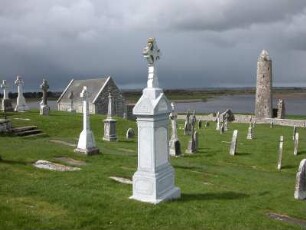 Clonmacnoise am Shannon-River ist Irlands bedeutendste frühmittelalterliche Klosteranlage, gegründet 545. Bild: Friedhof mit Hochkreuzen und Festungsturm, rechts