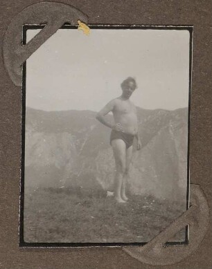 Heinrich Zimmer in Badehose auf einer Wiese vor Bergkulisse stehend