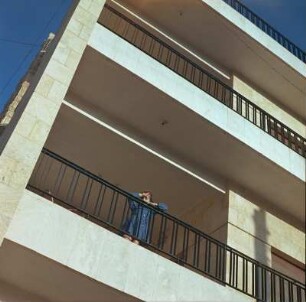 Mädchen auf dem Balkon eines modernen Wohnhauses