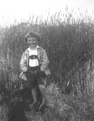 Junge mit Lederhose, an einem Kornfeld stehend