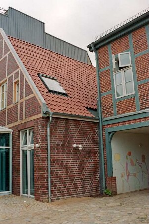 Mühlenstraße 21: giebelständiges Wohn- und Geschäftshaus: nach Sanierung: rückwärtige Giebelseite mit Fachwerk: rechts traufständiges Fachwerkhaus mit Tordurchfahrt [angeschnitten]: oben hinten Kaufhaus Nickel [angeschnitten]