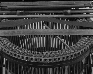 Typenhebelschreibmaschine "Remington" (Modell 5). Unteranschlag (nicht sofort sichtbare Schrift), Universaltastatur mit 42 Tasten, 36-mm-Farbband. Detail: Typenhebelsektor mit angehobenem Hebel und Farbband (Walze aufgeklappt) : Typenhebelschreibmaschine "Remington" (Modell 5). Unteranschlag (nicht sofort sichtbare Schrift), Universaltastatur mit 42 Tasten, 36-mm-Farbband. Detail: Typenhebelsektor mit angehobenem Hebel und Farbband (Walze aufgeklappt). Baujahr: 1886/1897; Hersteller: Remington and Sons Ilion, N. Y. Verwalter: Sächsische Landesbibliothek - Staats- und Universitätsbibliothek Dresden (SLUB), Stenografische Sammlung, Inventar-Nummer R i 0021