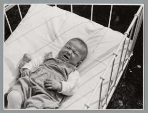 Portrait eines Kleinkindes in Kinderbett liegend