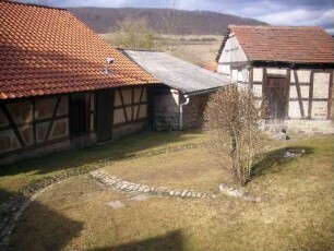 Kirchhof im Nordwesten von Südosten mit Gaden in Übersicht (Fachwerk-Gaden mit Backsteinausmauerung auf Kellergeschoß)
