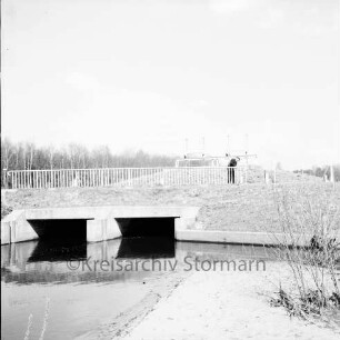 Alster: Wulksfelder Weg: Wulksfelder Schleuse: Schleusenbrücke mit Geländer: rechts daran Mann: vorn rechts Sträucher