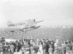 Menschenmenge an Bord des Hochseepassagierdampfers "Bremen" beobachtet den Start des Katapultflugzeugs HE 12 D-1717