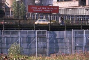 DDR-Grenzsperranlage bei Blankenstein : Ein Auto vom Typ "Trabant" fährt hinter den DDR-Grenzsperranlagen an der Saale bei Blankenstein, aufgenommen ca. 1986