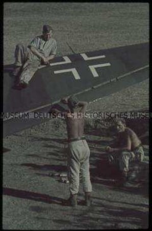 Soldaten auf und am Tragflügel eines Flugzeugs