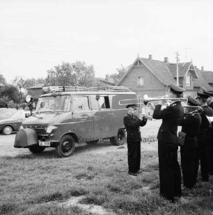 Freiwillige Feuerwehr: Übergabe eines neuen Löschfahrzeugs: vorn rechts Feuerwehrkapelle: links Feuerwehrmänner beim Fahrzeug: im Hintergrund Bauernhaus