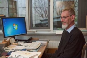 Porträt Perk Loesch, Fachreferent der SLUB : Porträt des Kunstwissenschaftlers Perk Loesch, Fachreferent und von 1996 bis 2019 Leiter der Handschriftenabteilung an der Sächsischen Landesbibliothek – Staats- und Universitätsbibliothek Dresden (SLUB). Aufnahme an seinem Schreibtisch