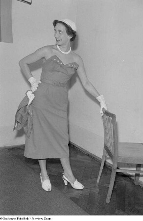 Eine Frau posiert mit Sommerkleid und Hut bei der "Internationalen Messemodenschau", Herbstmesse 1953