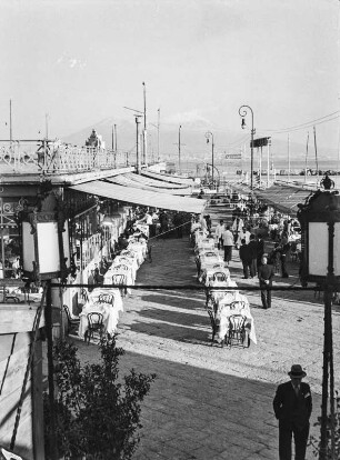Strandpromenade : Tische vor Cafes am Hafen von Abessinien