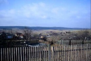 Blick zum Ort über einen Zaun