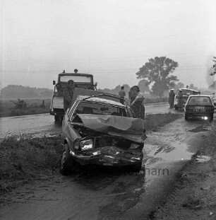 Verkehrsunfall: Landesstraße zwischen Bargteheide und Hammoor: Zusammenstoß von zwei Personenwagen: nasse Fahrbahn: Abschleppwagen, Abtransport eines Pkw mit eingedrücktem Vorderteil, Frau: hinten Einsatzwagen der Polizei, Polizisten: auf Fahrradweg Regenpfützen, 19. August 1980