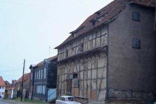 Straße mit alter Herrschaftsscheune vorn, dahinter ehemalige Schenke