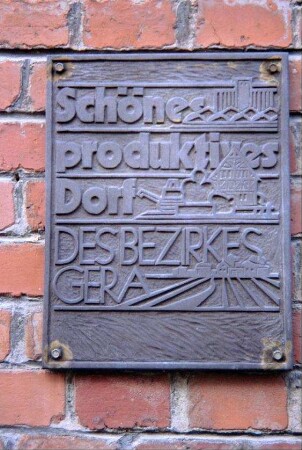 Tafel an der alten Schule: "Schönes produktives Dorf des Bezirkes Gera"